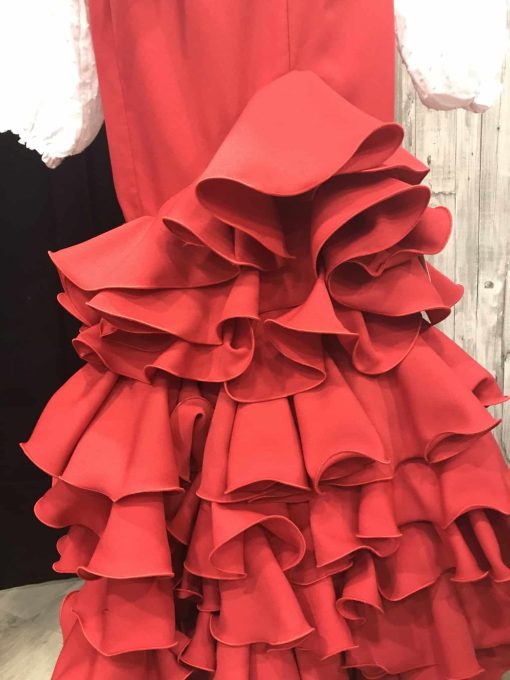 Falda rociera roja con seis volantes para encargar en la talla que desees, confeccionada en tejido streck con un movimiento espectacular