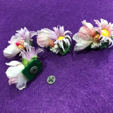 Tocado floral bebe compuesto por flores de papel y tela pequeñitas con clip para colocar en el pelo y terminar de adornar la indumentaria huertana de tu bebe.