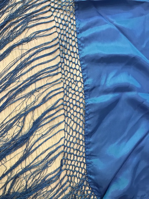 Manton pico huertana en color azul para niña confeccionado en raso y flecos cosidos a mano