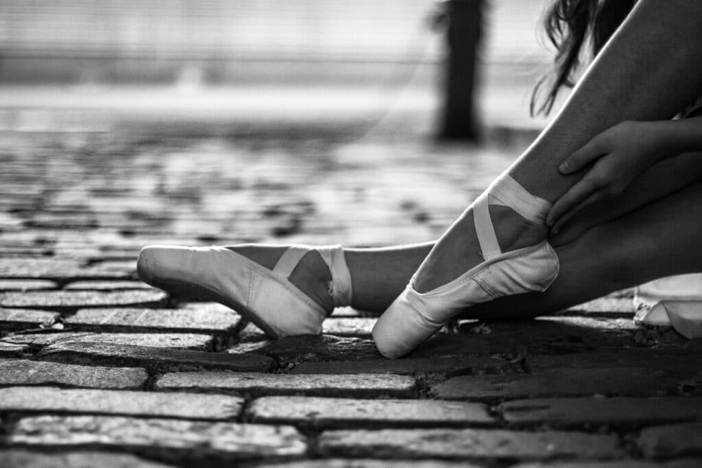 Bailarina atando cintas puntas ballet