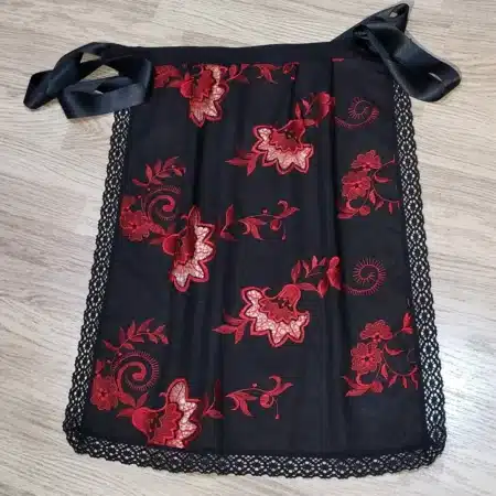 Delantal huertana bordado negro con flores rojas y encaje tradicional murciano